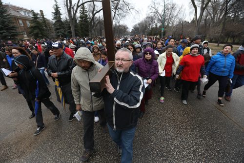 RUTH BONNEVILLE /  WINNIPEG FREE PRESS

Shawn Coughlin, who teaches some music classes at St. Mary's Academy,  helps carry the cross through streets surrounding her school during the 30th Annual Public Way of the Cross on the morning of Good Friday.
Bishops, teachers and students took turns helping to carry the cross through the streets of Crescentwood led by singers and followed by a few thousand people.  The event was co-sponsored by St. Mary's Academy and the Archdiocese of Winnipeg Office of Youth and Young Adult Ministry. 
April 14, 2017