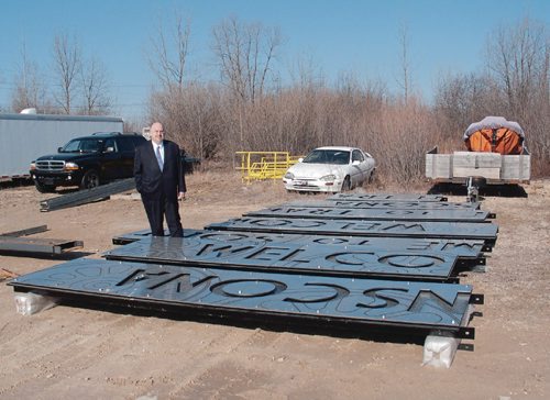 Canstar Community News April 12, 2017 - Coun. Russ Wyatt (Transcona) admires the new stainless steel "Welcome to Transcona" and "Welcome to South Transcona" signs, manufactured by Atlast Welding (3924 Main St.), that will welcome visitors to the Park City as they travel through the Plessis Underpass. (SHELDON BIRNIE/CANSTAR/THE HERALD)