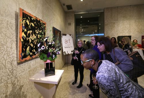 RUTH BONNEVILLE /  WINNIPEG FREE PRESS

People look closely at a floral arrangement by OTR Consultants, Floral Designers that interprets the Art work on wall by Tony Ssherman, Bowl of Fruit at the opening night of the, art in bloom. event at the WAG Thursday evening.
 Standup photo 
April 20, 2017