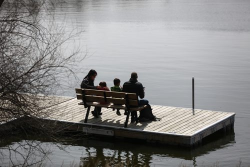 MIKE DEAL / WINNIPEG FREE PRESS
(from left) Shanna Chan and her kids, Laine Burley, 4, and Cade Burley, 6, with husband Brent Burley sit on a bench on the dock at FortWhyte Alive. FortWhyte Alive hosted their annual Earth Day celebration on Sunday.
170423 - Sunday, April 23, 2017.