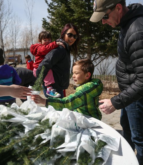 MIKE DEAL / WINNIPEG FREE PRESS
Cade Burley, 6, is handed a free tree sapling while his sister, Laine, and parents Shanna and Brent look on. FortWhyte Alive hosted their annual Earth Day celebration on Sunday.
170423 - Sunday, April 23, 2017.