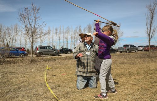 MIKE DEAL / WINNIPEG FREE PRESS
Volunteer Peter H. helps Grace Kammerlock-Butcher, 6, try out an Atl Atl during the FortWhyte Alive annual Earth Day celebration on Sunday.
170423 - Sunday, April 23, 2017.