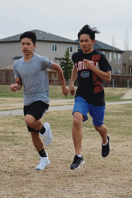 Canstar Community News April 20, 2017 - West Kildonan Collegiate track and field athlete Jestoni Villanueva (right) and James Jose (left) warm up before a practice during lunch hour. (LIGIA BRAIDOTTI/CANSTAR COMMUNITY NEWS/TIMES)
