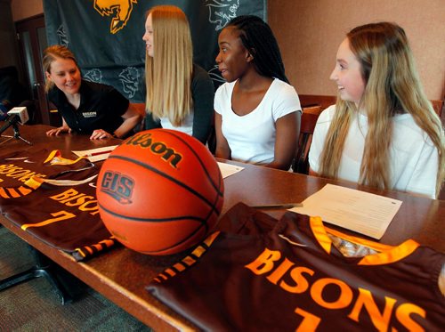 BORIS MINKEVICH / WINNIPEG FREE PRESS
University of Manitoba Bison athletics press conference at Smitty's 2835 Pembina Hwy.  From left, women's basketball head coach Michele Sung (Hynes), Dana Inglis, Bettina Shyllon, and Deidre Bartlett. Here they wait to sign papers to join the Bisons Women's basketball team. April 24, 2017