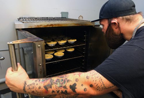 WAYNE GLOWACKI / WINNIPEG FREE PRESS

49.8 INTERSECTION.   Checking on his Pot Pies baking in the oven . Dustin Watson is the Lord of the Pies, he founded the biz in Sept 2016 . He is working in the United community kitchen to prepare his pies. Dave Sanderson story. April 24 2017