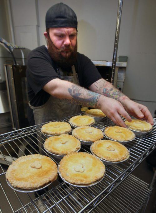 WAYNE GLOWACKI / WINNIPEG FREE PRESS

49.8 INTERSECTION.   Dustin takes hot pot pies out of the oven and places them on a rack.   Dustin Watson is the Lord of the Pies, he founded the biz in Sept 2016 . He is working in the United community kitchen to prepare his pies. Dave Sanderson story. April 24 2017