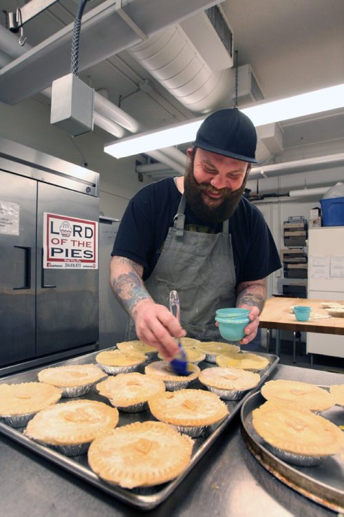 WAYNE GLOWACKI / WINNIPEG FREE PRESS

49.8 INTERSECTION.     Dustin Watson is the Lord of the Pies, he founded the biz in Sept 2016 . He is brushing egg on the pie tops before they go in the oven in the United community kitchen. Dave Sanderson story. April 24 2017