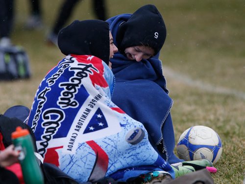 JOHN WOODS / WINNIPEG FREE PRESS
Linden Christian Wings players Katarina Uruski and Kennedy Selley try to stay warm on the sidelines as they play Faith Academy Lightning in the snow at Simkin Park Monday, April 24, 2017.