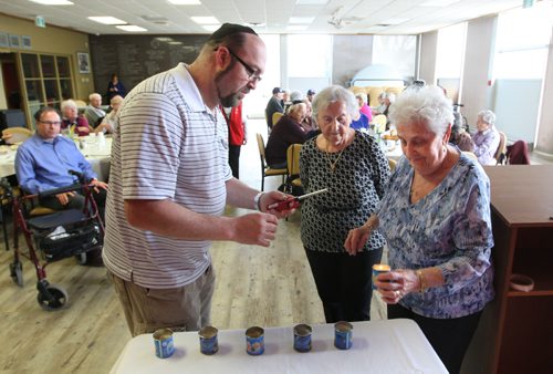 WAYNE GLOWACKI / WINNIPEG FREE PRESS

From right, Holocaust survivors Ruth Zimmer and her sister Anne Novak light candles with help from Keith Elfenbein with the Jewish Child and Family Service who hosted the Holocaust memorial service Thursday held at the Gwen Secter Creative Living Centre. Matt Olson story  April 27 2017