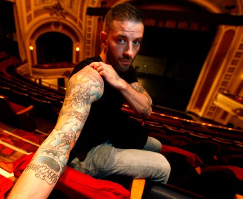 PHIL HOSSACK / WINNIPEG FREE PRESS  -  Darcy Oake poses at the Burton Cummings Theatre showing a tattoo on his arm showing an angel and two cherubs representing him and his brother Bruce who died of an over dose, dates of his birth and death are inscribed at the bottom.  -  May 3, 2017