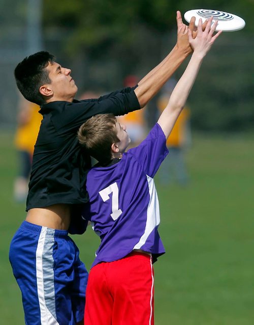 BORIS MINKEVICH / WINNIPEG FREE PRESS
Louis Riel School Division middle years Ultimate league play at Hastings School fields. From left, Shamrock School player Tyson Surinx goes over top to steal the disc from École Marie-Anne-Gaboury's #7 Daniel Green. STANDUP PHOTO. May 3, 2017