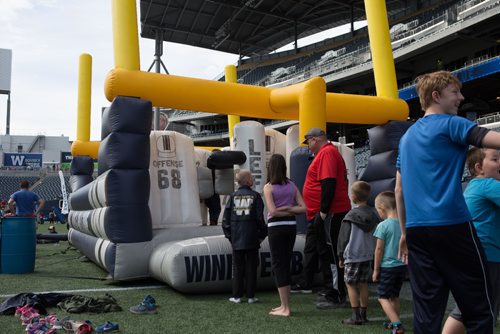 JEN DOERKSEN/WINNIPEG FREE PRESS
Kids and youth line up to try out the defensive bouncy castle during the Bombers Fan Fest. Young athletes and families were welcomed onto the field at Investors Group Field to hone their football skills. Saturday, May 6, 2017.