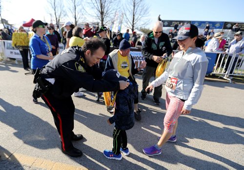 TREVOR HAGAN / WINNIPEG FREE PRESS
Winnipeg Police Service Chief Danny Smyth hangs a medal on Louis Orbeta, 6, as Ann Bautista looks on at the finish line. The 13th annual Winnipeg Police Service Half Marathon started and finished in Assiniboine Park, Sunday, May 7, 2017.