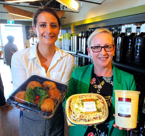 BORIS MINKEVICH / WINNIPEG FREE PRESS
RESTAURANT REVIEW - Agora Market at 1765 Kenaston Blvd.  From left, employees Stephanie Baron and Tanya Hill hold some take out small portion meals that are popular. They stand in front of a wall of olive oil. ALISON GILMOR STORY. May 9, 2017