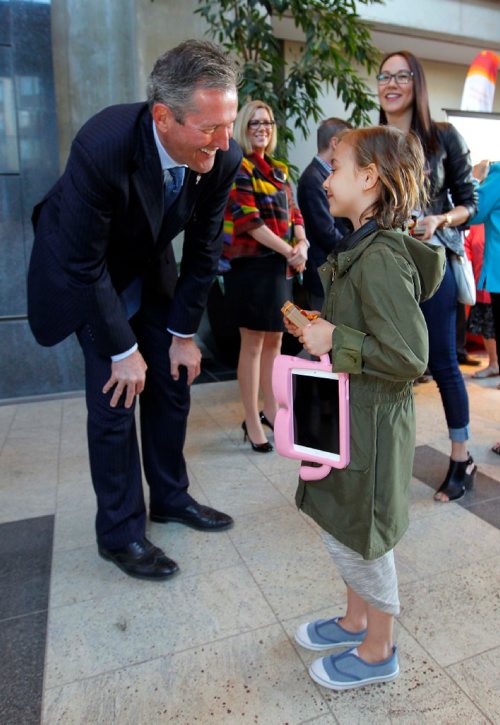 BORIS MINKEVICH / WINNIPEG FREE PRESS
CANADA GAMES TORCH RELAY EVENT - The 2017 Canada Games Host Society had an event at MB Hydro headquarters to honour and celebrate individuals who will carry the Roly McLenahan Torch, as part of the Manitoba Hydro Torch Relay. Manitoba Premier Brian Pallister, left, congratulates torch bearer Mila Gaslard,7, right, as her mom Kimberly Moors watches, right (behind Mila in bluejeans). CAROL SANDERS STORY. May 12, 2017