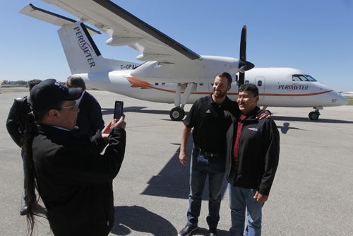 BORIS MINKEVICH / WINNIPEG FREE PRESS
The Winnipeg Blue Bombers announce a partnership with Perimeter Aviation and Exchange Income Corporation today for a new community program benefitting First Nations youth from 12 communities in Northern Manitoba. Blue Bombers quarterback Matt Nichols, middle, gets a photo taken with Chief Joe Antsanen, Northland Denesuline First Nation, right, at Perimeter Aviation Hangar, 50 Morberg Way (behind 614 Ferry Road). No ID for man on the left taking the photo with cell phone. ALEXANDER PAUL STORY. May 12, 2017