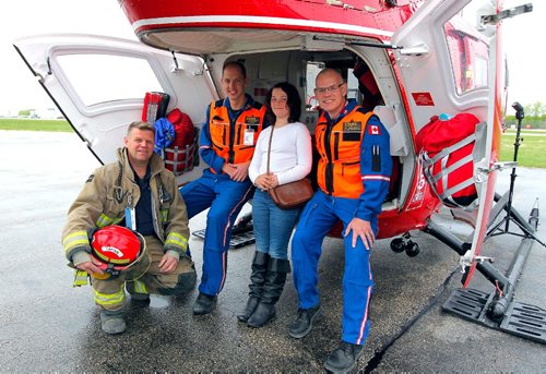 BORIS MINKEVICH / WINNIPEG FREE PRESS
Charity Edwards was transported by STARS in late 2015 after being struck by a vehicle while riding her bicycle in the Grunthal area. She sustained critical life-threatening injuries. She was at the STARS base at the airport today meeting some of the people who were involved in her rescue. From left, Grunthal Volunteer Fire Dept. Capt. Carl Reimer, STARS pilot David Harris, Charity Edwards, and STARS Medical Director Doug Martin. They posed for a group shot in the back of the chopper.. RANDY TURNER STORY. May 16, 2017