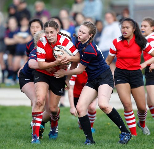 PHIL HOSSACK / WINNIPEG FREE PRESS  -   Kelvin Clipper #12 Chey Winogradoff (centre in red) works her way through St Mary's Acadamy opposition Tuesday at Kelvin. The cross street rivals met on the rugby field Tuesday afternoon. l  -  May 16, 2017
