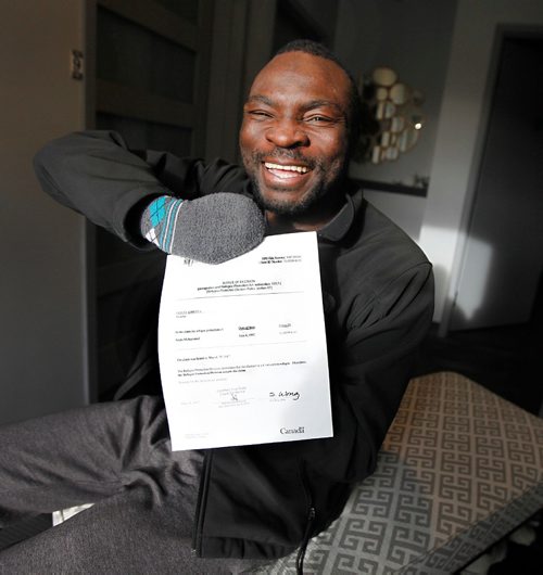 PHIL HOSSACK / WINNIPEG FREE PRESS  -   Flashing his trademark grin Seidu Mohammed shows off his refugee claimant approval Wednesday evening. See Carol Sanders story.    -  May 17 2017