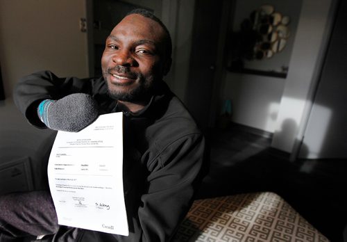 PHIL HOSSACK / WINNIPEG FREE PRESS  -  A relieved and happy Seidu Mohammed shows off his refugee claimant approval Wednesday evening. See Carol Sanders story.    -  May 17 2017