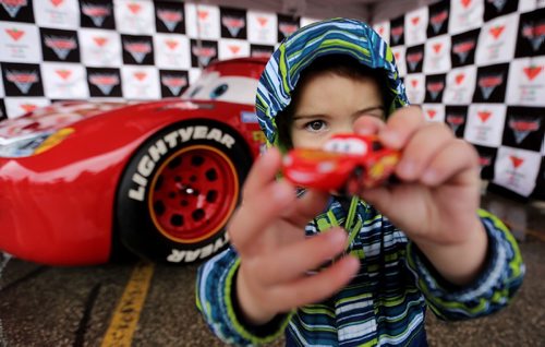 TREVOR HAGAN / WINNIPEG FREE PRESS
Finn Baker, 3, proudly shows off his Lightning McQueen toy car after having his photo taken with the life size version in the Grant Park Mall parking lot, Sunday, May 21, 2017.