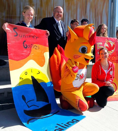 BORIS MINKEVICH / WINNIPEG FREE PRESS
From left low, The 2017 Canada Games Mascot named Niibin and Eyes of the Nation Ambassador Tracy Bowman pose for a photo with the student artists from Immanuel Christian School and the street banners they painted at the event. Standing behind Niibin is City councillor Russ Wyatt. 2017 Canada Summer Games, organizers and volunteers are calling on the community to help prepare its host cities for the arrival of 4,000 athletes and coaches, and 20,000 visitors this summer. The community initiative, entitled Eyes of the Nation, aims to leverage the Games to build a positive image of Winnipeg, Gimli, and Kenora in the hearts and minds of all Canadiansand in the process ignite a renewed sense of pride in the community. Event took place at Transcona Centennial Square. BILL REDECOP STORY. May 23, 2017