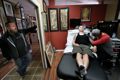 WAYNE GLOWACKI / WINNIPEG FREE PRESS 

Standing at left, Rich Handford, the owner of Kapala Tattoo, St. Anne's Rd. watches as Dale Irving gets work on his shoulder by tattooer Sean Cushnie. Melissa Martin story   May 23 2017
