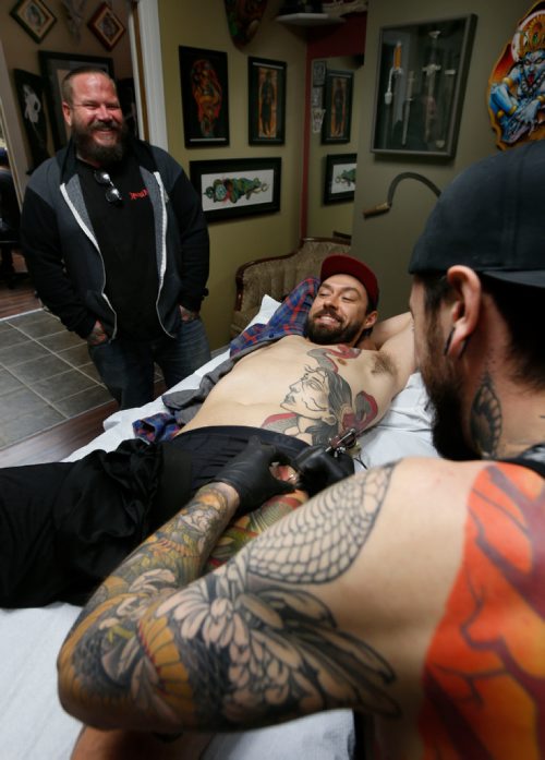 WAYNE GLOWACKI / WINNIPEG FREE PRESS 

At left Rich Handford, owner of Kapala Tattoo, St. Anne's Rd. is bringing 200 tattooists -- including some of the world's most renowned artists -- to Winnipeg for the city's first tattoo convention.  At right, Keegan Misanchuk gets work on his side panel by tattooer Dan Fletcher at Kapala. Melissa Martin story   May 23 2017