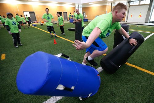 JOHN WOODS / WINNIPEG FREE PRESS
Riley Kraeker bursts through the bags as former Blue Bomber Neil McKinlay and other players look on at the Doug Brown KidSport Winnipeg Football Camp at the University of Winnipeg Sunday, May 28, 2017.