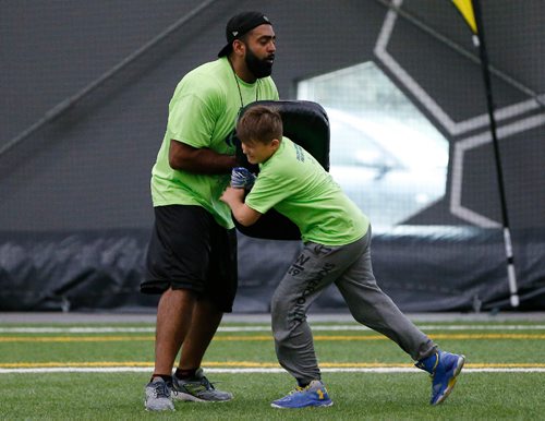 JOHN WOODS / WINNIPEG FREE PRESS
Former Blue Bomber Obby Khan holds the bag during a drill for the young players at the Doug Brown KidSport Winnipeg Football Camp at the University of Winnipeg Sunday, May 28, 2017.