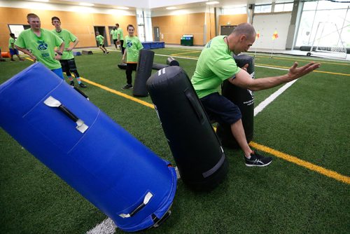 JOHN WOODS / WINNIPEG FREE PRESS
Former Blue Bomber Neil McKinlay demonstrates a drill for the young players at the Doug Brown KidSport Winnipeg Football Camp at the University of Winnipeg Sunday, May 28, 2017.