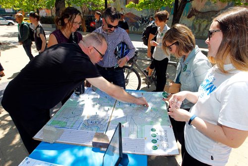 BORIS MINKEVICH / WINNIPEG FREE PRESS
From left, (leaning over marking the map) Derek Manaigre, Karen Kornelsen, David Pensato, Lea Coté, Green Action Centre, and Heather Mitchell, Green Action Centre, at a map that people put pins on representing where they commute from. The annual Commuter Challenge is a national celebration of healthy and sustainable transportation taking place during the first week of June. Close to 8,000 Manitobans participate every year by taking the bus, carpooling, walking or cycling to work. Winnipeg has won the past 12 out of 13 years as the top performing city in Canada. Photo taken at Red River College, Paterson GlobalFoods Institute, Bijou Park. June 1, 2017