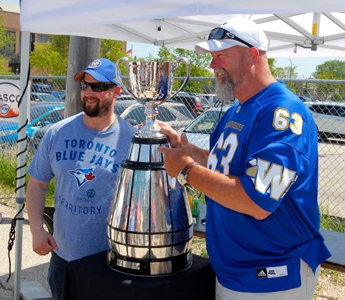BORIS MINKEVICH / WINNIPEG FREE PRESS
Photo op for former Winnipeg Blue Bomber Chris Walby with the Grey Cup at Rasco FR on Mountain Ave. The company is proud to be launching its Canadian flagship store in Winnipeg. Rasco FR Grand Opening today and tomorrow (Friday, June 2 and Saturday, June 3) A meet and greet and pictures with Winnipeg Blue Bombers CFL Alumni Chris Walby, and The Grey Cup. A complimentary Dannys Whole Hog BBQ and Smokehouse lunch was served. From left, Ryan Kristalovich, and Chris Walby pose with the Grey Cup.  June 2, 2017

