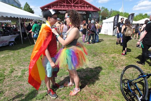 RUTH BONNEVILLE /  WINNIPEG FREE PRESS

Mercedes Benzie (right) ties a pride flag around her friend Charlie Dilk's neck during Pride Celebrations at the Forks stage area Saturday.



June 03, 2017