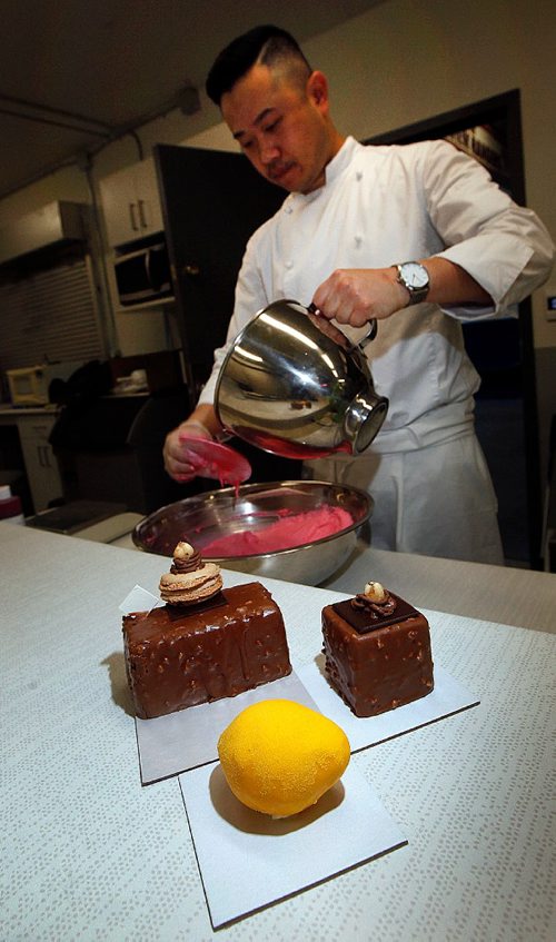 PHIL HOSSACK / WINNIPEG FREE PRESS  -  INTERSECTION - "S Squared Patisserie" Chef Sophon Chhin prepares macarons behind a sampling of some of his cakes Monday at the Riverview Community Centre where he uses the kitchen to churn out sweet pasteries and more.   See Dave Sanderson story.  -  June 2, 2017