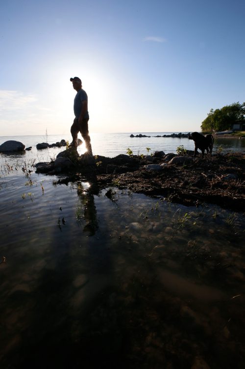 WAYNE GLOWACKI / WINNIPEG FREE PRESS

Dave Olson lives in Peonan Point, a peninsula in the northern part of Lake Manitoba. He is standing along the lake with his dog Minks by the family home.    Bill Redekop story. June 9  2017