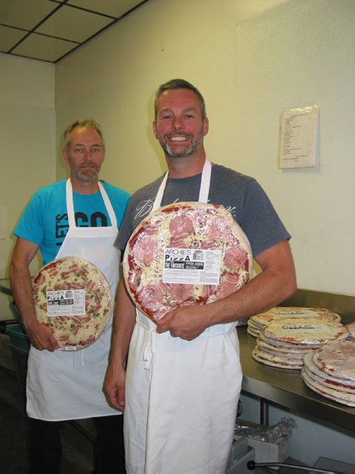 Canstar Community News May 31, 2017 - (From left) Ray and Phil Mollot, owners of Archie's Meats in Starbuck, show two of the ten varieties of pizzas they sell. (ANDREA GEARY/CANSTAR COMMUNITY NEWS)