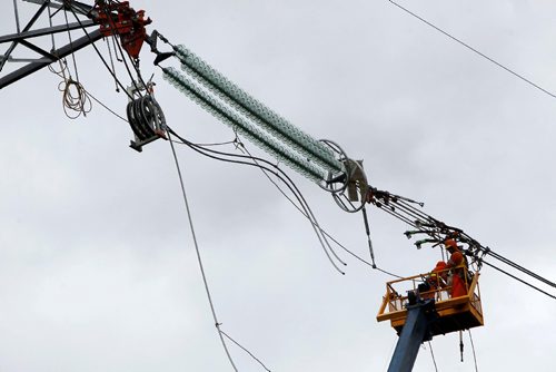 BORIS MINKEVICH / WINNIPEG FREE PRESS
Power lines for Manitoba Hydro Bipole III (3)  get installed near the transcanada Highway #1 and #12 Highway, near Dufresne, Manitoba. Here workers on a crane lift prepare the lines and insulators. June 15, 2017
