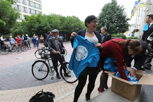 RUTH BONNEVILLE / WINNIPEG FREE PRESS

 City Councillor Jenny Gerbas tries on a Bike Week tshirt at CIty Hall for the  3rd annual Suit and Heels on Wheels ride Friday.  

 
June 16, 2017
