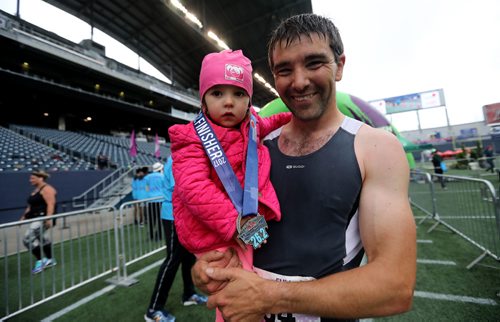 TREVOR HAGAN / WINNIPEG FREE PRESS
Full marathon participant, Murray Carter, carries his 2.5 year old daughter, Lucie, as he crosses the finish line at the 39th Manitoba Marathon, Sunday, June 18, 2017.