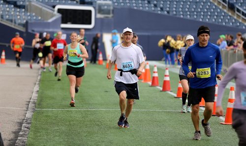 TREVOR HAGAN / WINNIPEG FREE PRESS
The 39th Manitoba Marathon, Sunday, June 18, 2017. Douglas Walker (centre) is flanked by fellow runners after entering Investors Group Field to complete the half marathon.