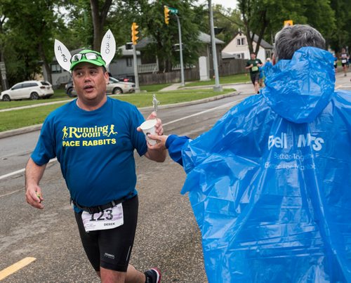 DAVID LIPNOWSKI / WINNIPEG FREE PRESS

Manitoba Marathon participants run and grab water on Harrow Street Sunday June 18, 2017.