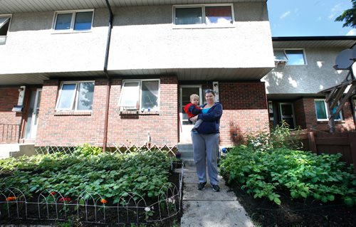 WAYNE GLOWACKI / WINNIPEG FREE PRESS

Korrina Hargreaves with her grandson Oli in her front yard garden of vegetables, herbs and flowers of her Manitoba Housing unit at 1380 Raleigh St. She and another friend at the property faced the prospect of having their flowers, herbs and vegetables ripped out because of a agency policy that prohibits planting anything but grass in front yards. Gord Sinclair story  June 19   2017