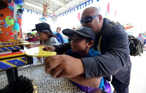 TREVOR HAGAN / WINNIPEG FREE PRESS
Gil Grande, with his sons, Haiden, 6, left, and Isaiah, 7, trying to win some prizes at the Ex. After poor weather over the last couple weeks, many people took the opportunity to visit the Red River Ex, Sunday, June 25, 2017.