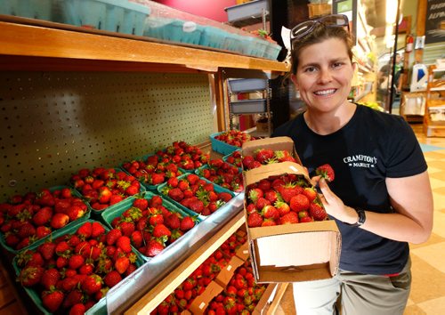 WAYNE GLOWACKI / WINNIPEG FREE PRESS

Erin Crampton, owner of Cramptons Market with a sample of some of fresh strawberries at the store.  Ben Waldman story   June 29   2017