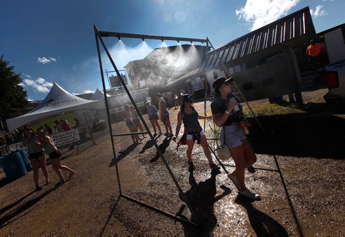 PHIL HOSSACK / WINNIPEG FREE PRESS  -  Festival goers and the temperature both heated up as the sun came oput Friday afternon at Dauphin's Country Festival. Partiers take the edge off under a cool mist provided for just such an emergency.   -  June 30 2017