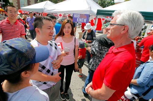 BORIS MINKEVICH / WINNIPEG FREE PRESS
Osborne Village Canada Day street festival was packed with people. Federal minister Jim Carr, right, listens to some stories from some new Canadians in the street. July 1, 2017
