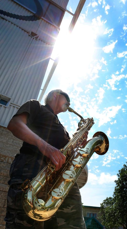 WAYNE GLOWACKI / WINNIPEG FREE PRESS

Busker John C. entertains people passing by with his baritone saxophone at the The Forks during the hot humid Tuesday afternoon.   July 4  2017