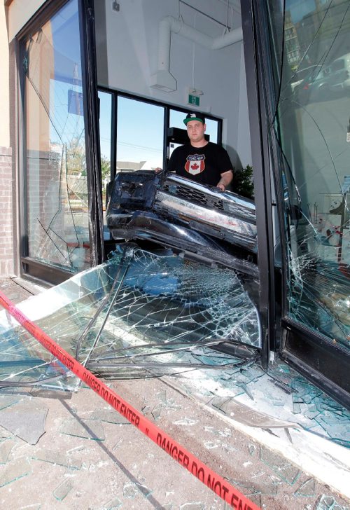 BORIS MINKEVICH / WINNIPEG FREE PRESS
Early this morning the Fat Panda shop on St. Annes was robbed when a black SUV rammed through their front windows. Here store manager Jayson Saltel holds the front bumper of what may be the suspect vehicle used in the robbery. A passerby found the bumper nearby.  July 5, 2017
