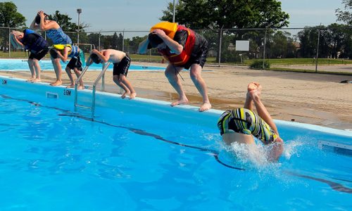 BORIS MINKEVICH / WINNIPEG FREE PRESS
Doug Speirs at Provencher Pool participates in the making of a video to promote drowning prevention week for the Lifesaving Society. Here he wears a bright coloured life jacket practicing a dive into the pool, second from right. July 10, 2017